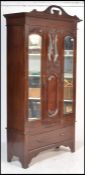 An Edwardian Art Nouveau walnut single wardrobe. Raised on a plinth base with drawer having mirror