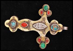 A white metal ethnic pendant cross set with gemstone / glass cabochons. Tests for silver in