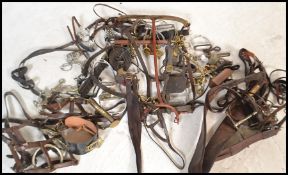 A collection of vintage horse tack to include brasses on Martingales, stirrups, reins, bridles,