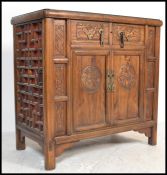 A good early 20th century Chinese sideboard cabinet having stunning carved, lattice decoration to
