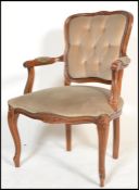 A 20th century beech wood French fauteuil armchair with champagne coloured velour fabric and show