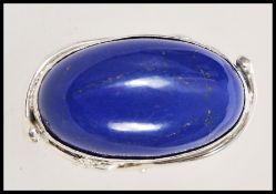 A stamped 925 silver ring having a large oval lapis lazuli stone with pierced floral decoration to