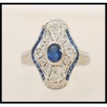 A 1920's 18ct white gold art deco panel ring set with a central oval cut sapphire in a shaped