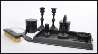 An early 20th Century ebony dressing table set, having a gallery tray, candlesticks, ring stand,