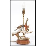 A vintage Capodimonte ceramic table lamp in the form of a bird raised on naturalistic scenery and