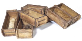A SET OF 10 MID CENTURY STACKING WOODEN INDUSTRIAL BRICK MOULDS