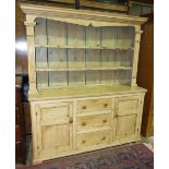 A 19th century pine dresser base with three central drawers flanked by cupboard doors, with later