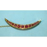 An Edwardian 9ct gold garnet and diamond crescent brooch set thirteen graduated garnets with diamond