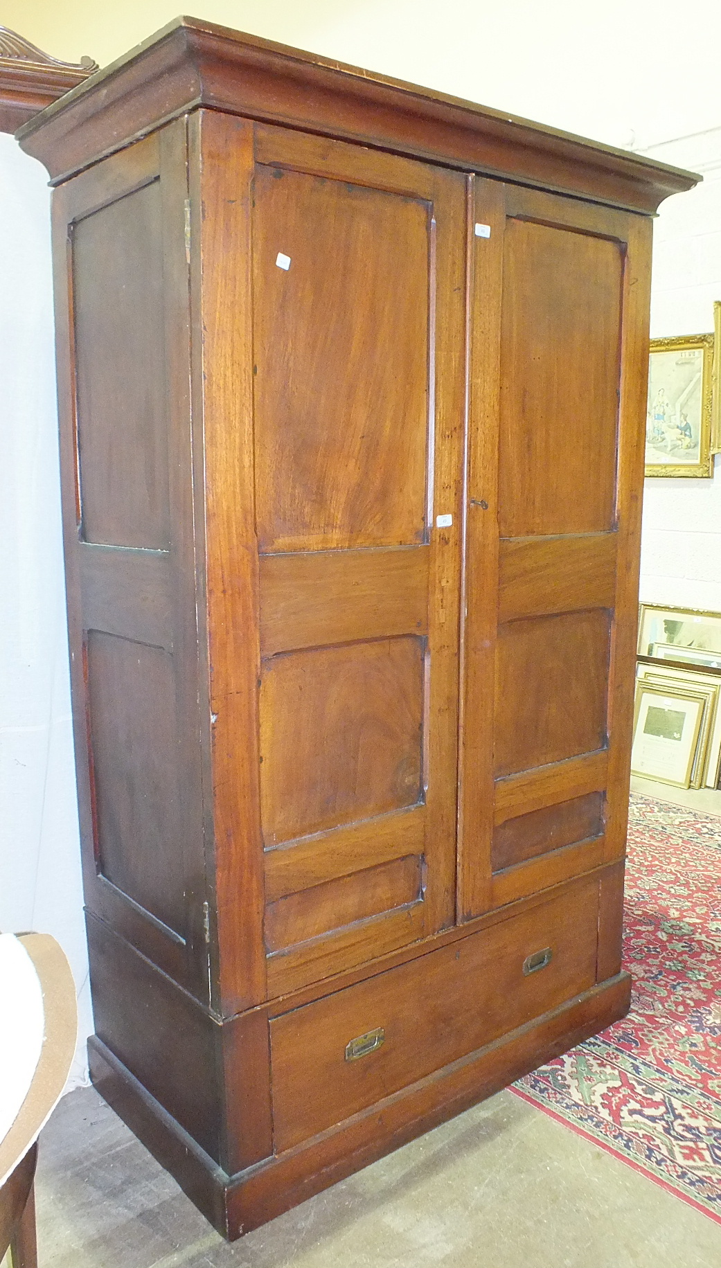 A hardwood panelled two-door wardrobe, 134cm wide, 213cm high.