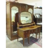 An Edwardian inlaid mahogany sectional wardrobe, the cornice above a central door flanked by a