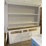 An antique rustic painted pine dresser, the moulded cornice above two shelves, the lower part fitted