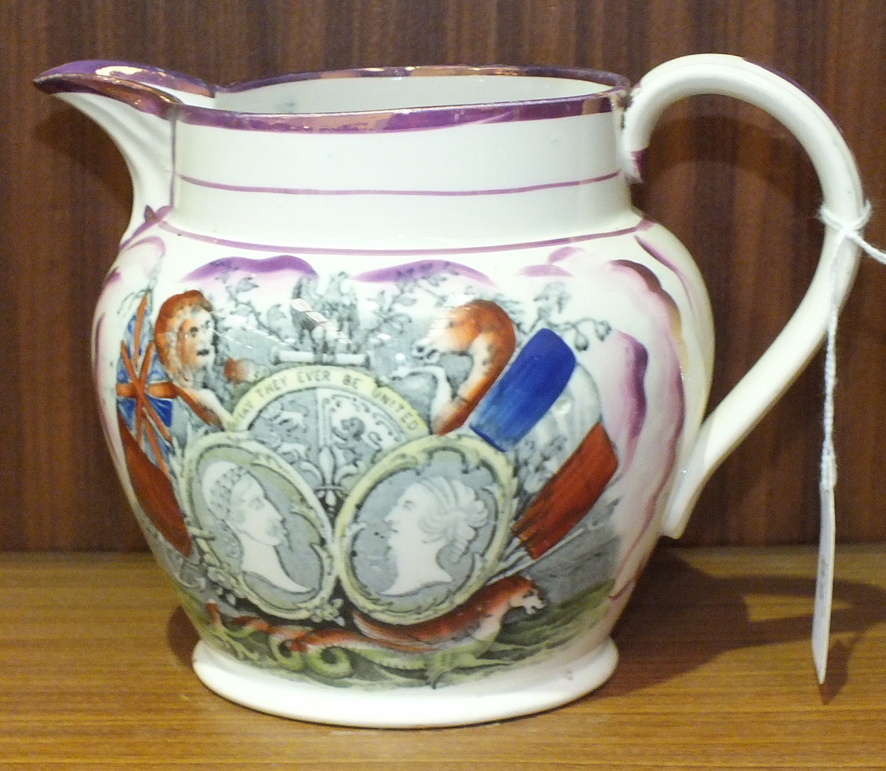 A Sunderland jug in pink lustre and black transfer decoration, having polychrome over painting