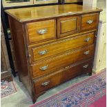 An Edwardian mahogany straight front chest, the rectangular top above a small central cupboard