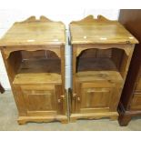 A pair of stained pine bedside cupboards, each fitted with a single door below a shelf, 41.5cm wide,