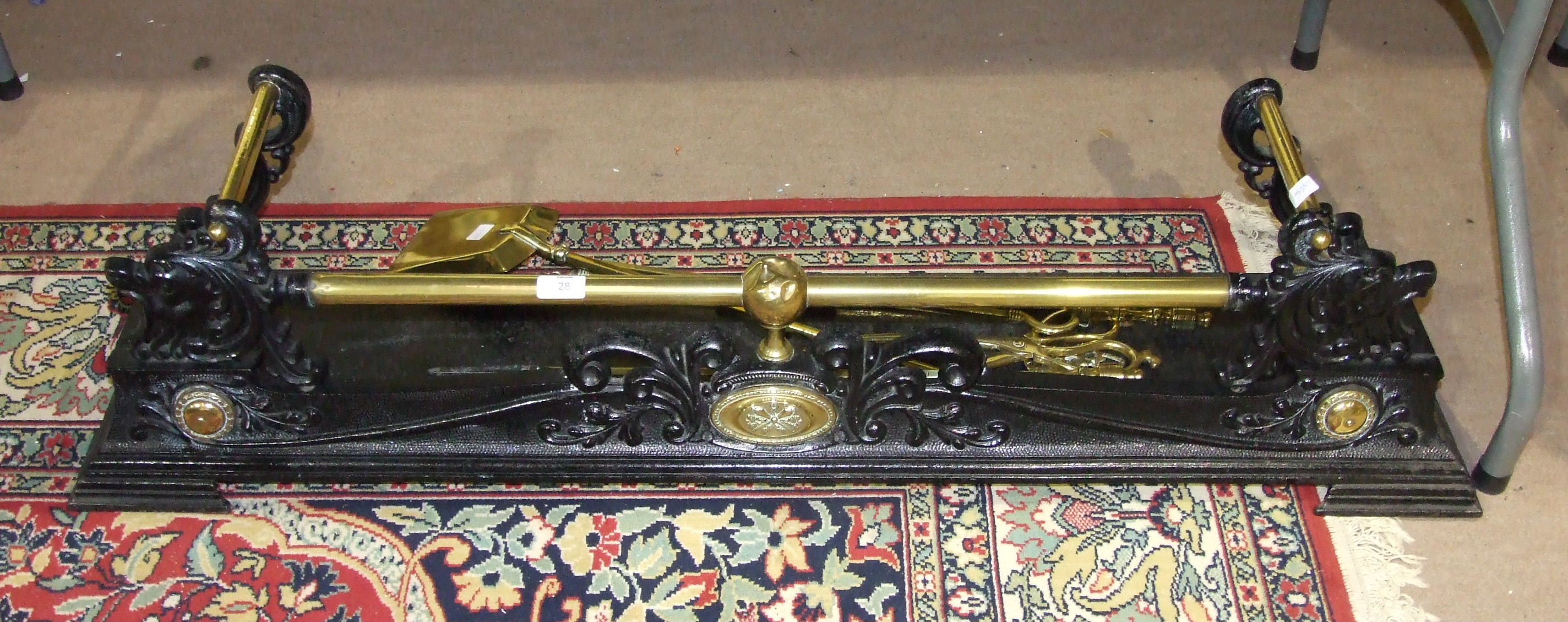A brass and iron fire curb, 122cm, a brass rail spark guard, 50.5cm wide, 61cm high, a set of