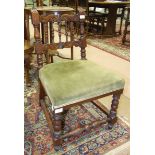 An upholstered-seat oak-framed nursing chair with carved spindle back and turned front legs.