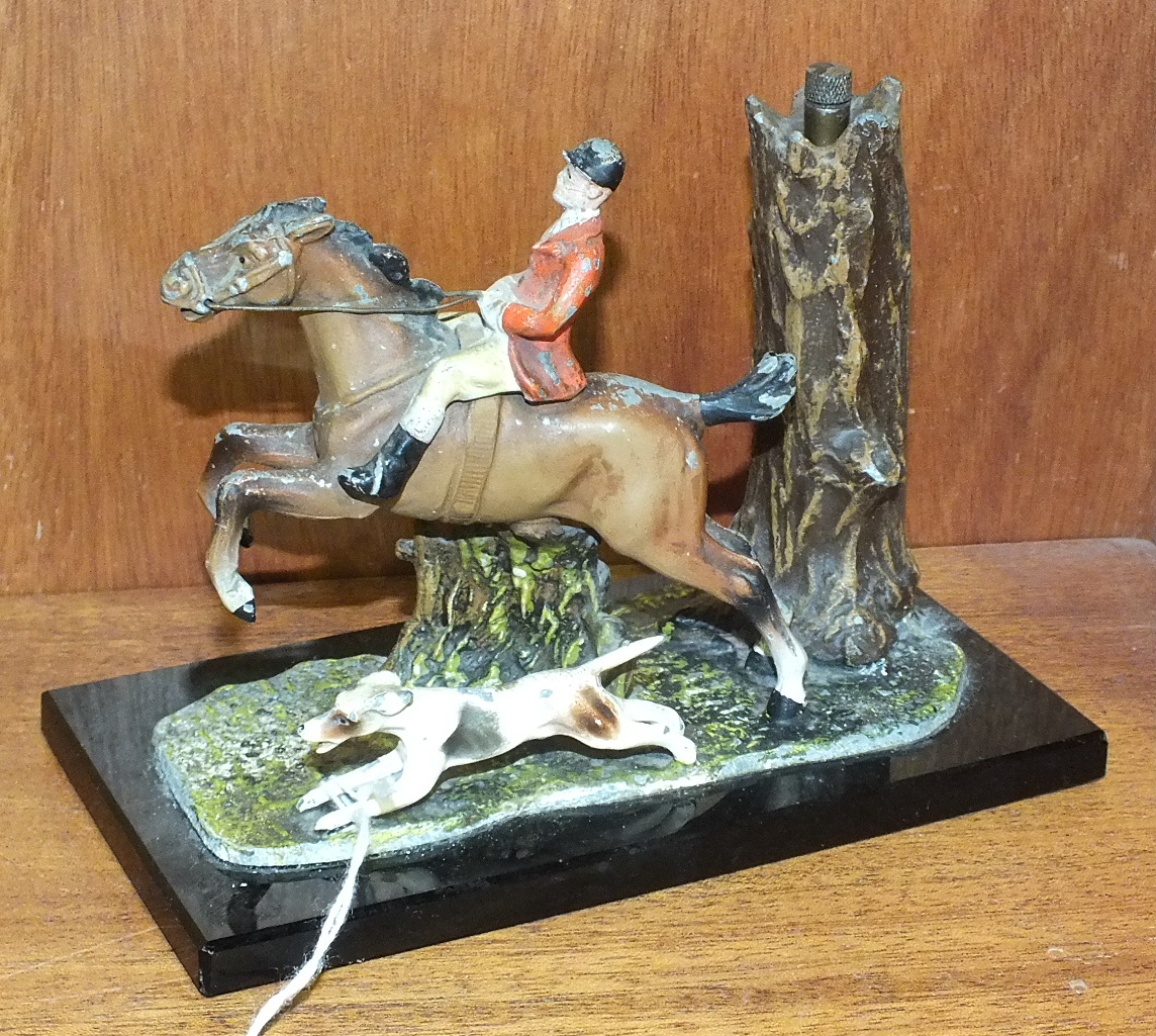 A 20th century painted spelter match strike in the form of a huntsman and hound, 11cm high, 15cm
