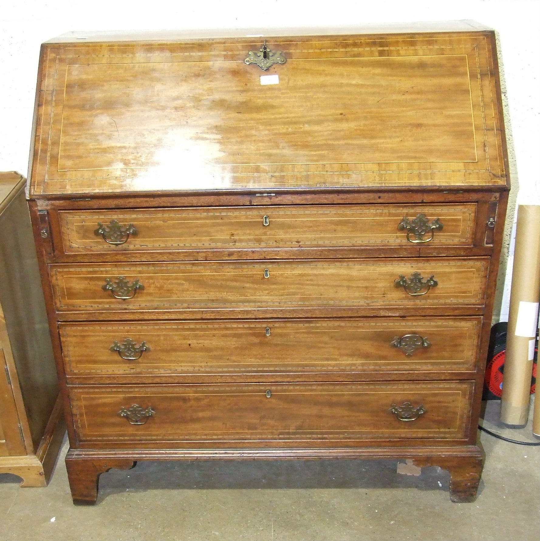 A Georgian inlaid mahogany bureau, the fall front opening to reveal drawers and pigeon holes,