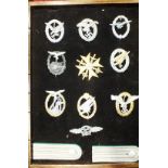 A collection of ten reproduction Luftwaffe badges and a pair of epaulettes, in glazed case.