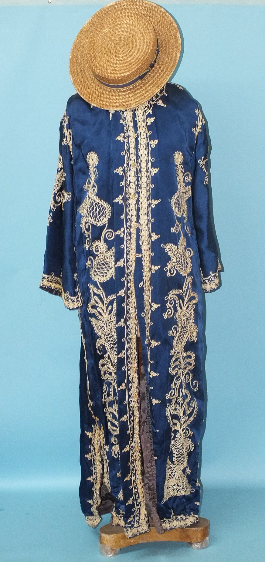 A deep blue satin coat, possibly Indian, with applied gold thread work, flared sleeves and side