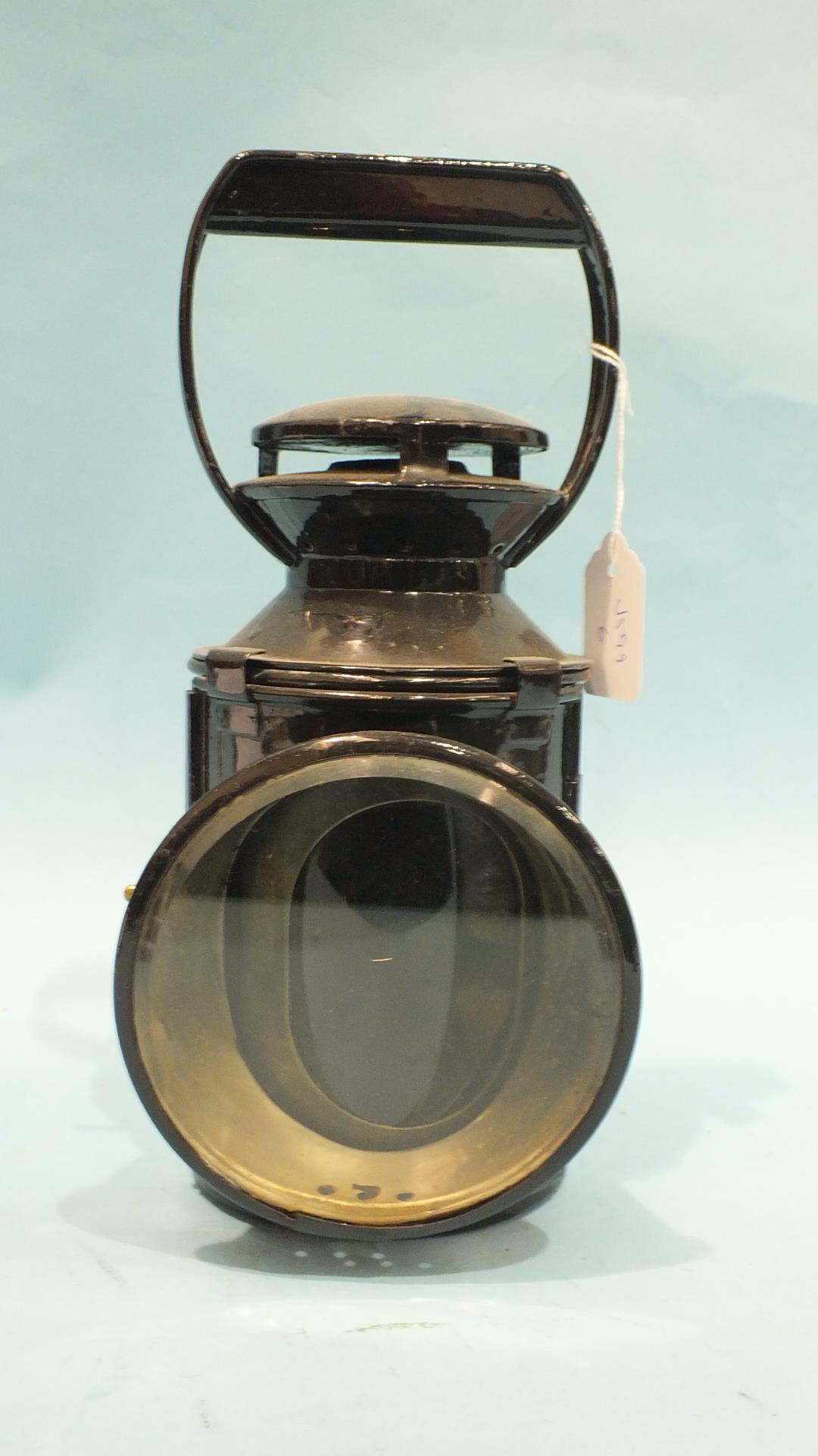 A Japanned four-aspect hand lamp with burner, reservoir, reflector and all four glasses.