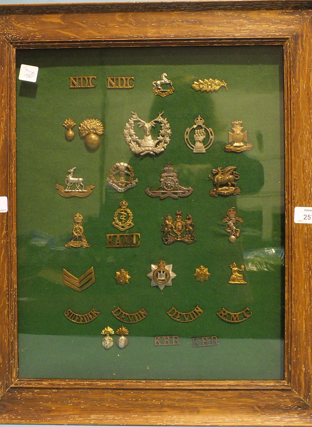 A collection of military caps and shoulder title badges, including 'Gordon Highlanders (BYDAND)', '