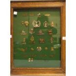 A collection of military caps and shoulder title badges, including 'Gordon Highlanders (BYDAND)', '