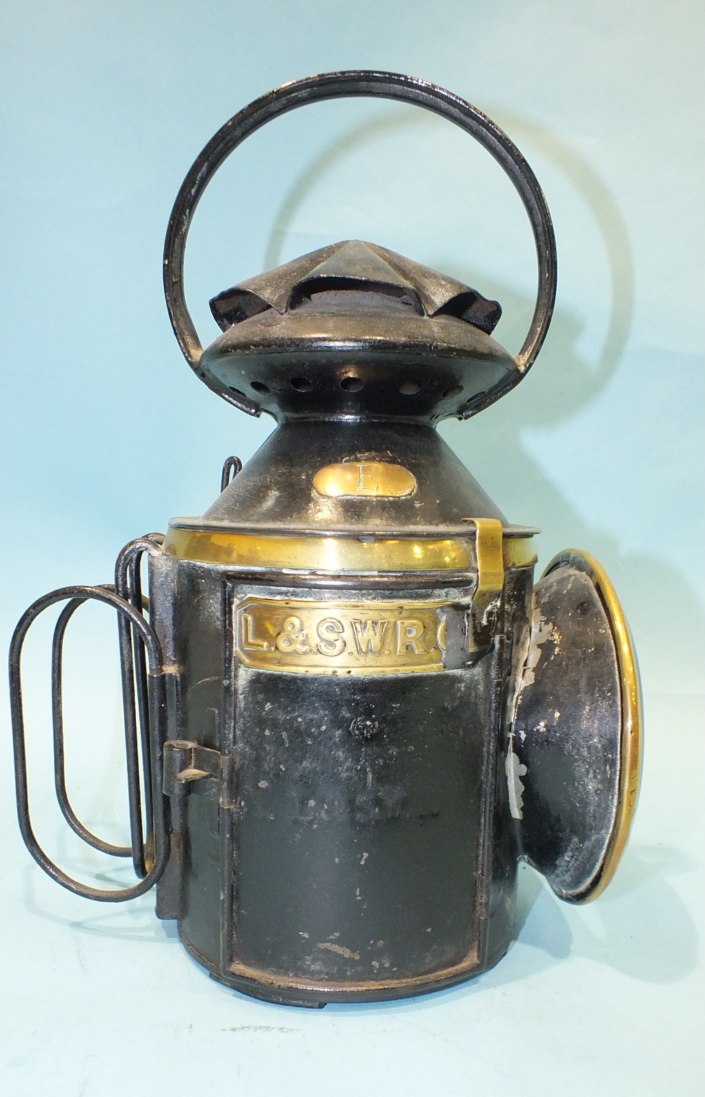 A Japanned LSWR four-aspect hand lamp with brass label and detail, stamped 'Tower Hill' on the side,