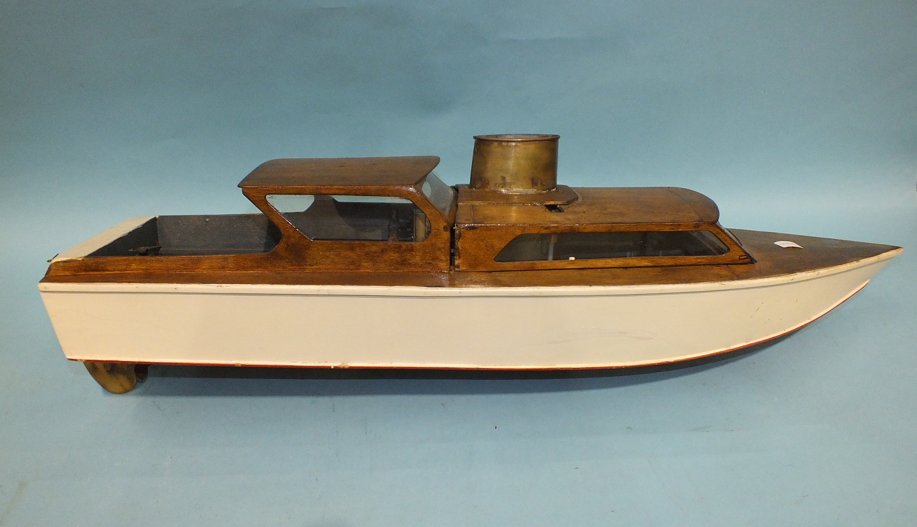 A scratch built live steam model of a boat, of wooden construction with brass boiler and funnel,