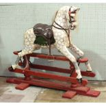 A Victorian rocking horse painted dapple grey with bridle, saddle and inset partial mane and tail,