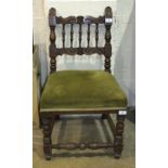 An upholstered-seat oak-framed nursing chair with carved spindle back and turned front legs.