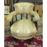 A Late-Victorian ebonised tub armchair, the padded back and arms on turned supports above an