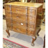 A low walnut chest, the shaped top above four drawers, on short cabriole legs and claw and ball