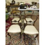 A set of four rosewood Victorian balloon back dining chairs, each with carved centre rail,