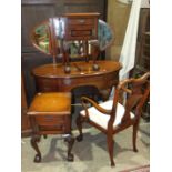 A modern mahogany finish dressing table, the triple mirror above an oval top and five drawers, on