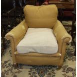 An early 20th century upholstered deep-seated arm chair with short tapering front legs and loose
