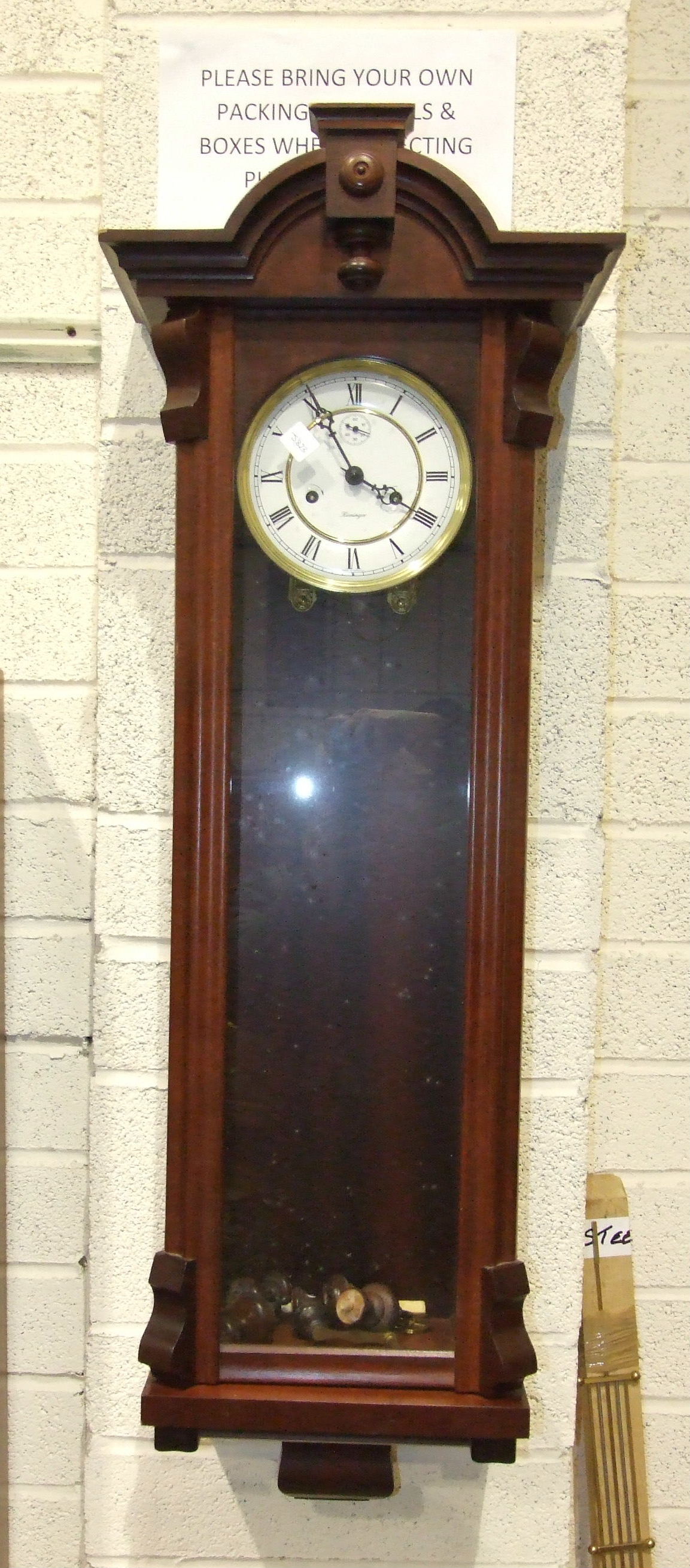A modern mahogany finish Vienna-type wall clock with gong-striking movement, enamel dial with