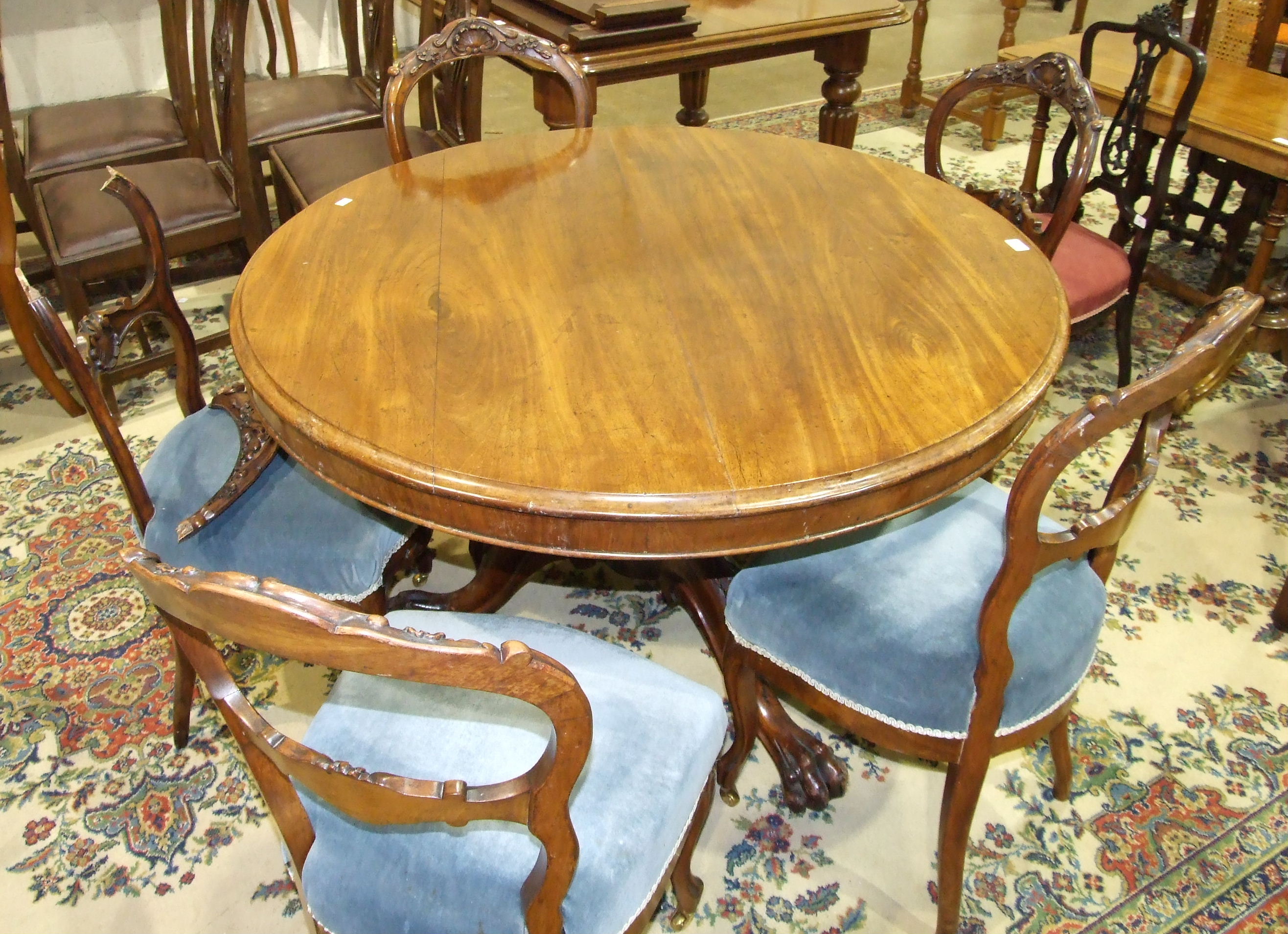 A Victorian mahogany circular breakfast table with moulded border, on turned column and carved