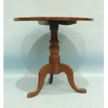 An antique oak tilt-top occasional table on turned column and tripod support, 75cm diameter.