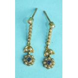 A pair of Edwardian drop earrings, each set a lilac stone and seed pearl flower-head cluster below
