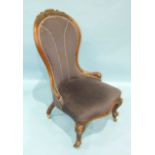 A Victorian walnut spoon-back nursing chair, the frame carved with flowers and with serpentine seat,