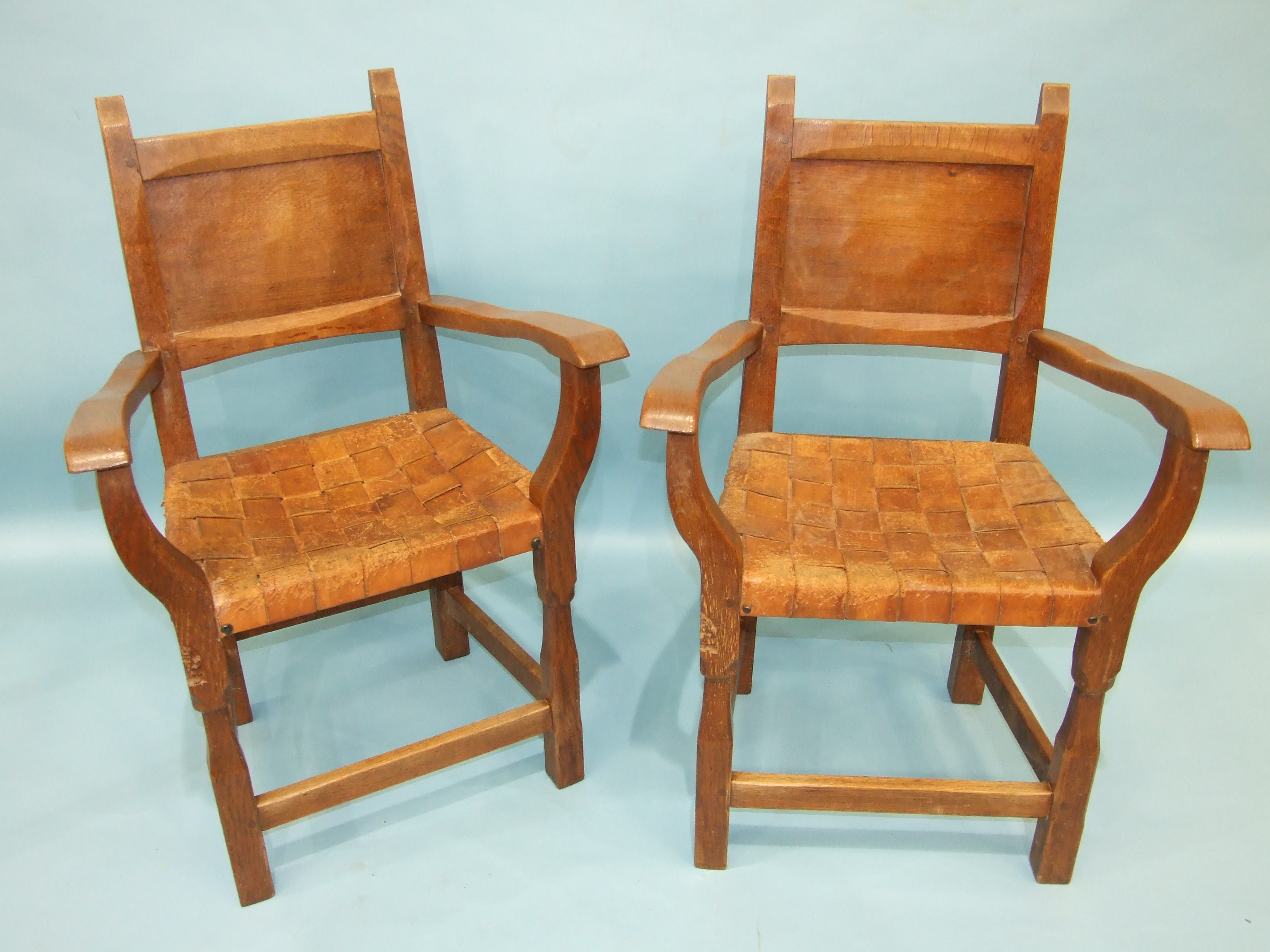 A pair of Thomas 'Gnomeman' Whittaker oak carver chairs, each with panelled back, woven-leather seat