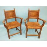 A pair of Thomas 'Gnomeman' Whittaker oak carver chairs, each with panelled back, woven-leather seat