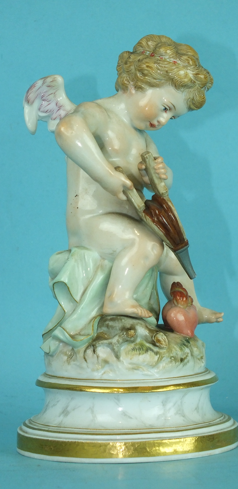 A 19th century Meissen porcelain figure of a winged cherub lighting the flaming heart with his