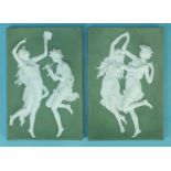 A pair of early-20th century Continental moulded ceramic plaques, decorated white on green with