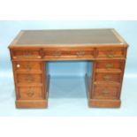 A late-Victorian walnut kneehole writing desk, the rectangular top with inset writing surface