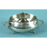 An Arts & Crafts-style beaten sugar bowl of compressed form with three stylised handles and feet,