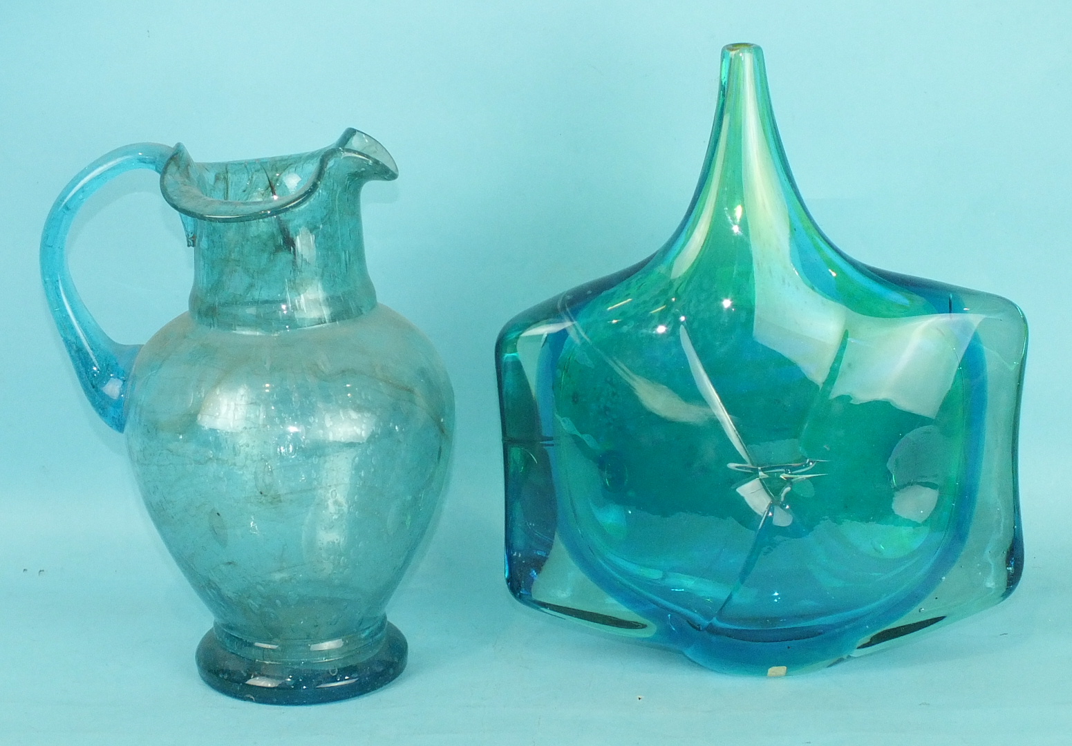 A Victorian bubble glass jug, pale blue colour, 27cm high and a 1960's mottled blue studio glass