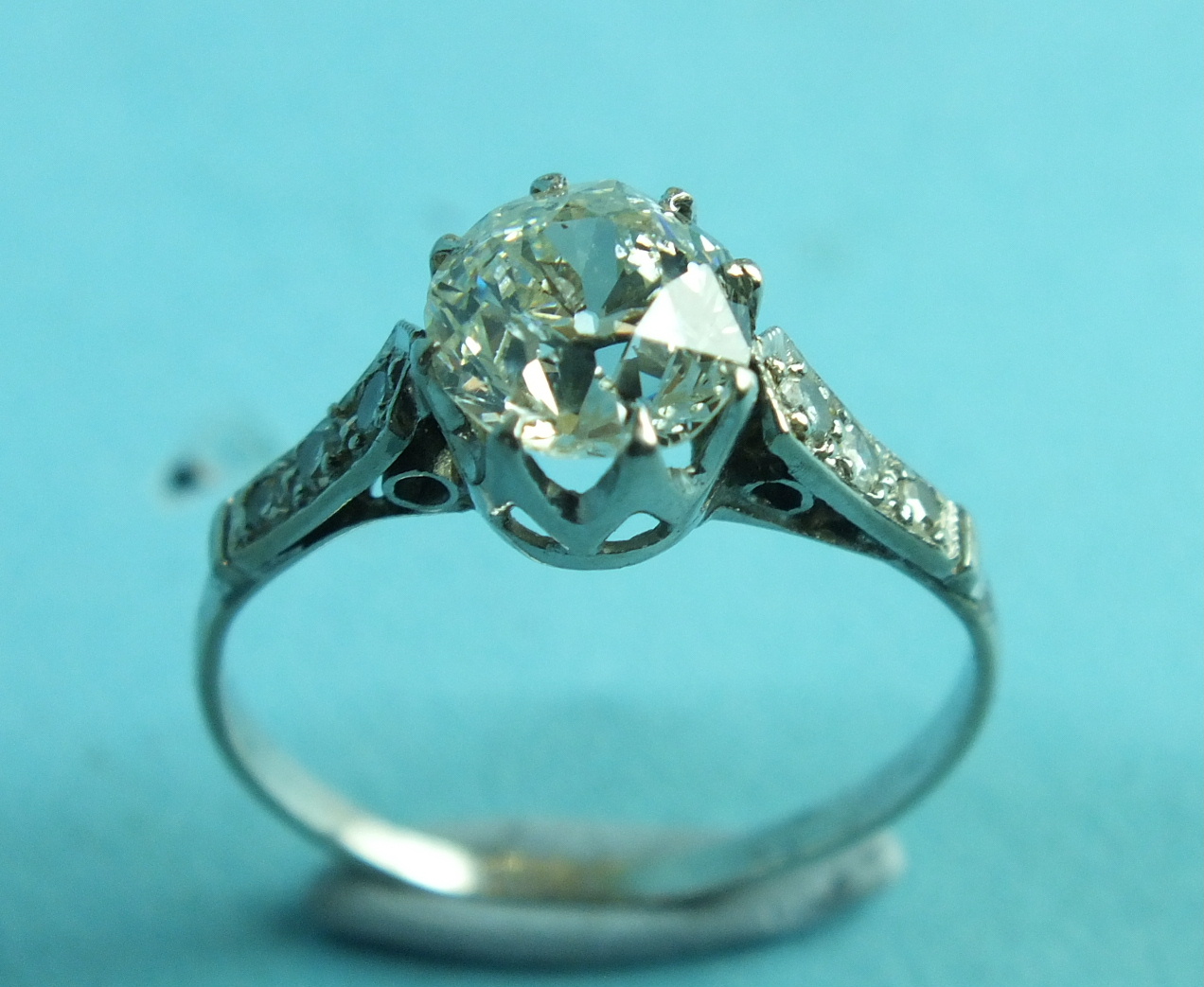 A solitaire diamond ring claw-set an old brilliant-cut diamond of approximately 1.4cts, between - Image 2 of 2