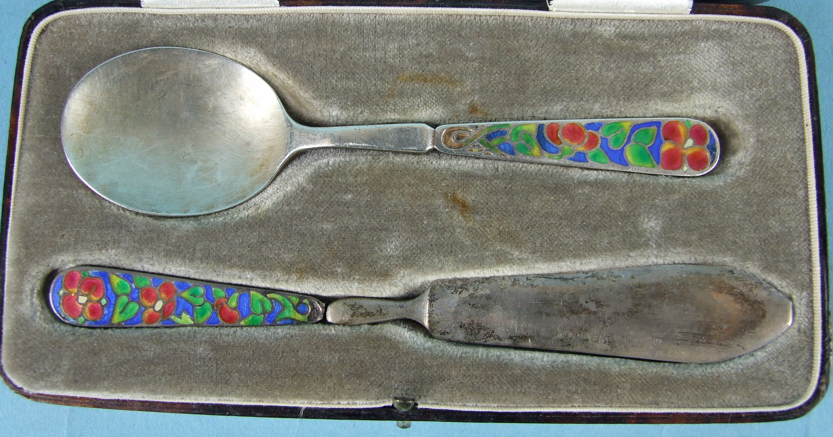 Bernard Instone, a cased Christening set consisting of a spoon and knife, the handles with red,